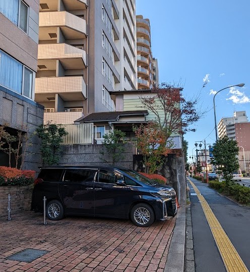 Kleine Häuser vor einem Hochhaus in Tokio