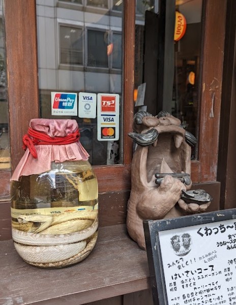 Figur und eingelegte Schlange in einem Schaufenster in Nihonbashi